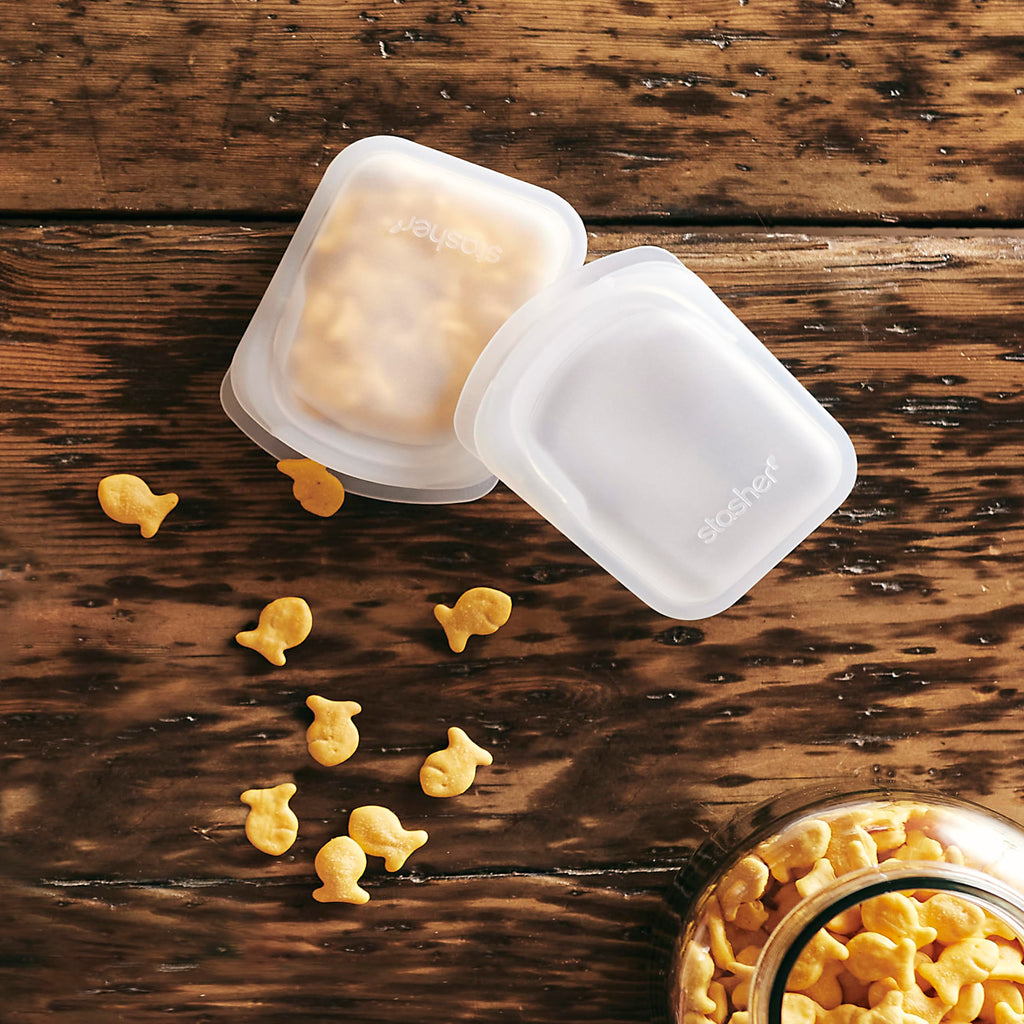 Stasher Silicone Reusable Storage Bag, Pocket Bags 2-Pack, Microwave, Dishwasher, Oven Safe, Sous Vide, Eco Friendly, Leak-free, Food-safe Silicone Snack Bags for Travel, 4 oz, Clear & Deep Ocean | Reusable Food Bags